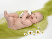 Baby auf grüner Decke und Blumen