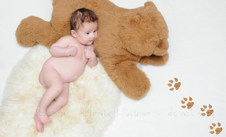 kleines Baby mit großem braunen Bären