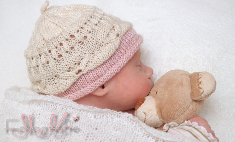 Portrait eines neugeborenen Babys, schläft mit Teddybär im Arm.