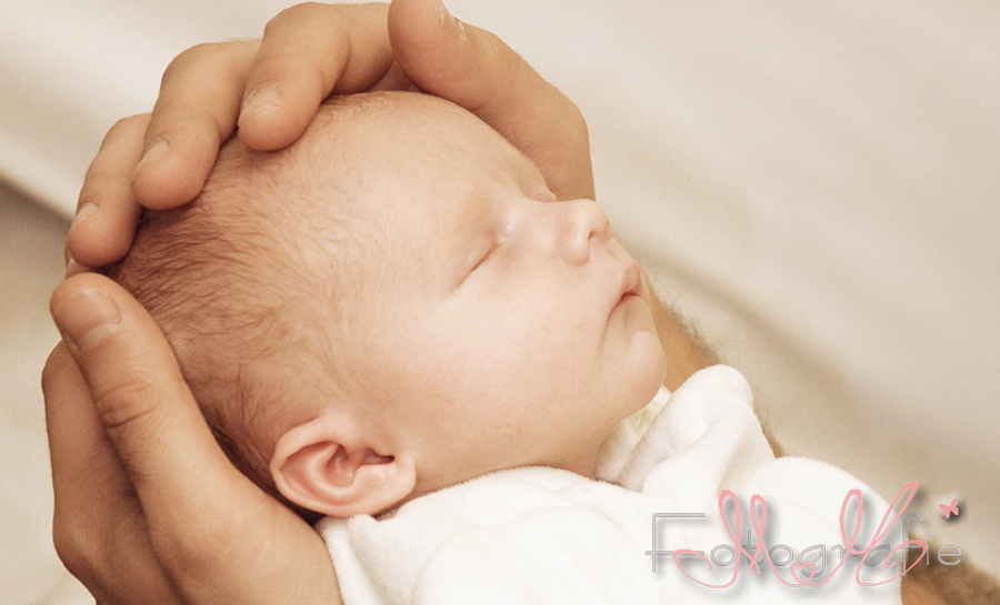 ein neugeborenes Baby liegt in den Händen seines Vaters
