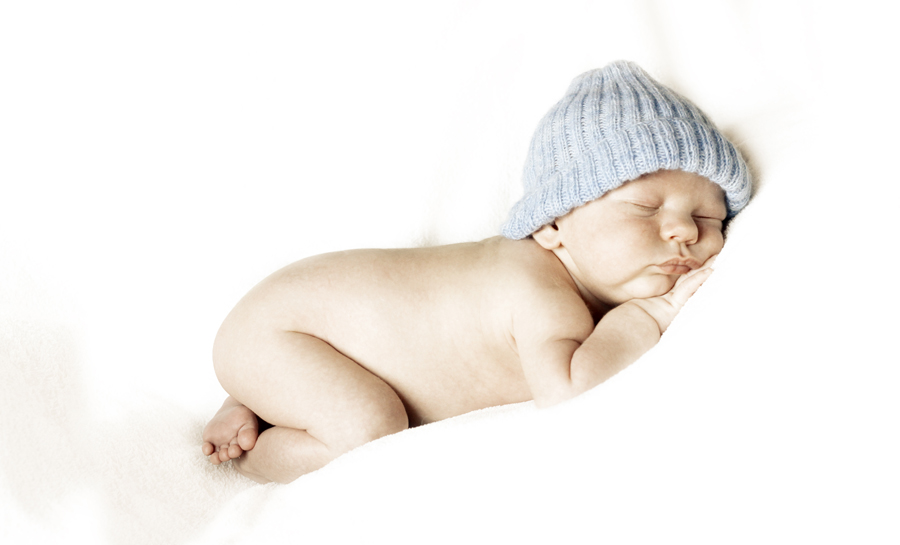 high-key-Foto eines schlafenden kleinen Babys mit blauer Mütze