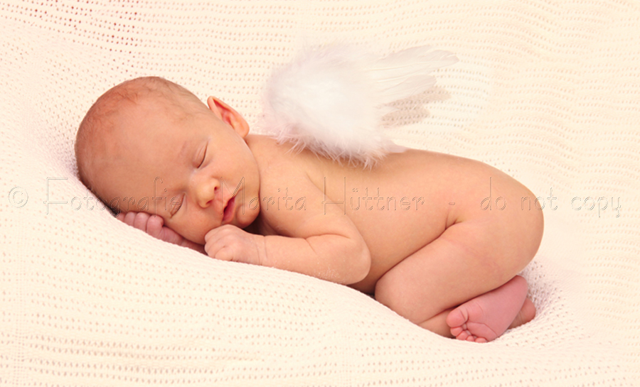 Foto eines neugeborenen Babys mit kleinen Engelsflügeln