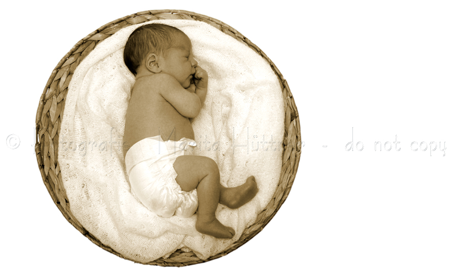 ein Baby liegt in einem runden Korb