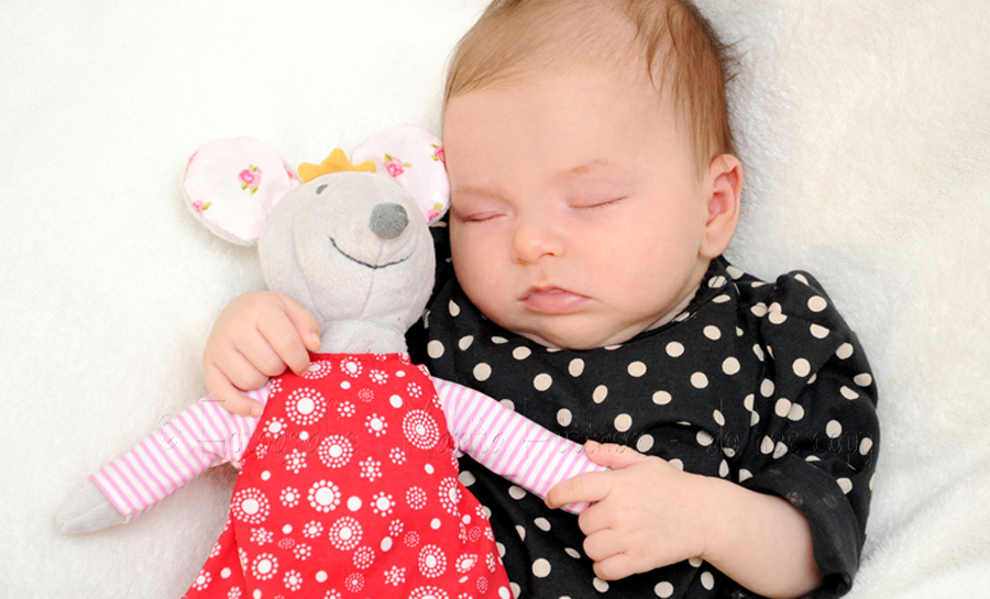 Schlafendes Baby mit Kuscheltier-Maus