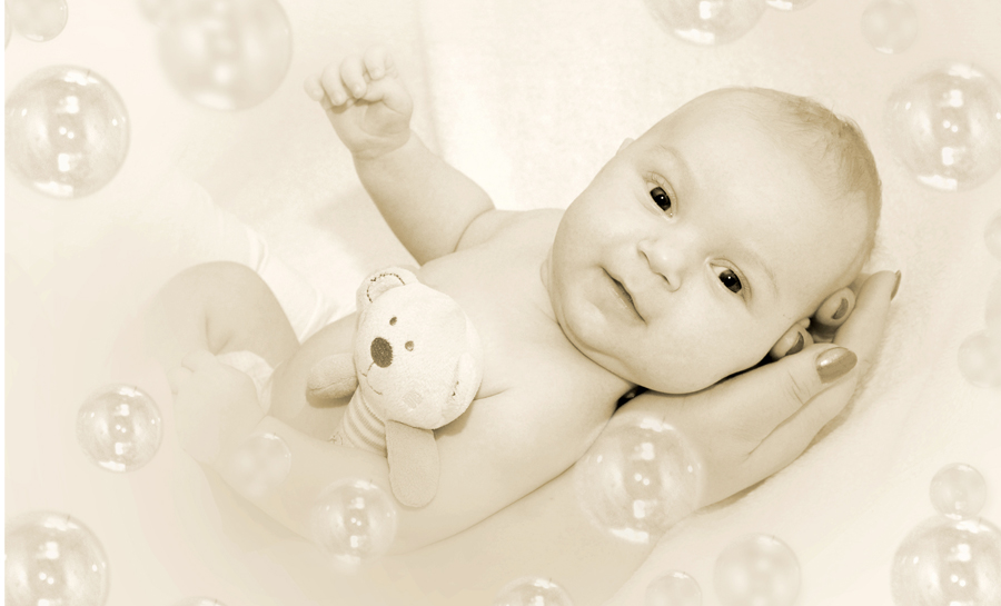 Baby wach in den Händen seiner Mutter mit Seifenblasen